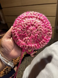 a person holding a pink crocheted bag