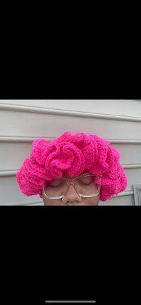 a person wearing a pink crocheted hat